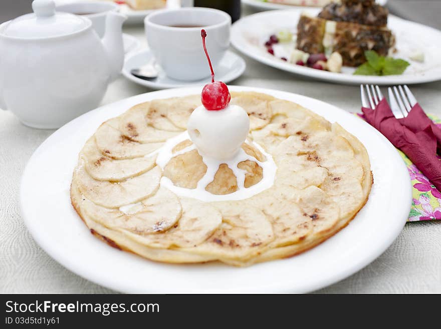 A table set with dessert, an apple pie with ice cream