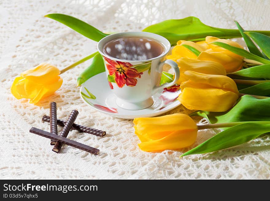 White cup of tea with red and yelow flowers. White cup of tea with red and yelow flowers