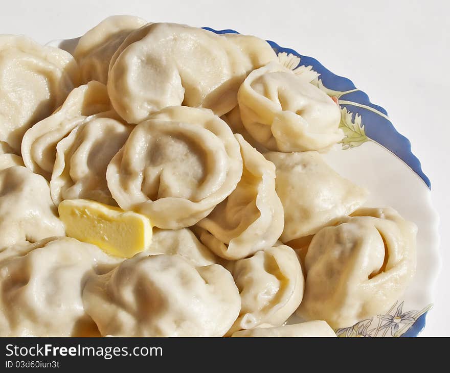 Ravioli with butter in a dish on a white background