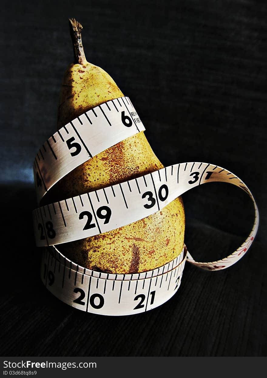 Diet concept: tape around a pear. Diet concept: tape around a pear