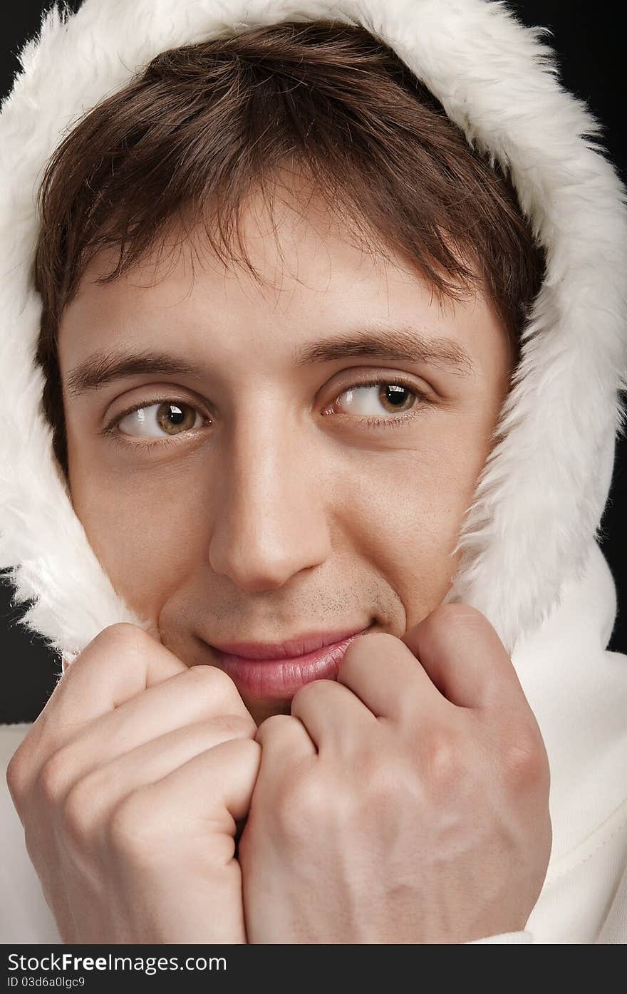 Closeup funny portrait of a man in the hood on a dark background