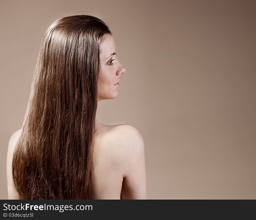 Sexy woman with long hair on a brown background