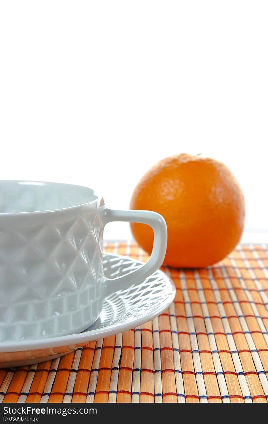 A mediterranean breakfast with an orange and a cu of coffee