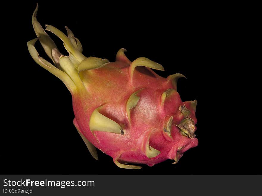 This is a dragon fruit over a black background.