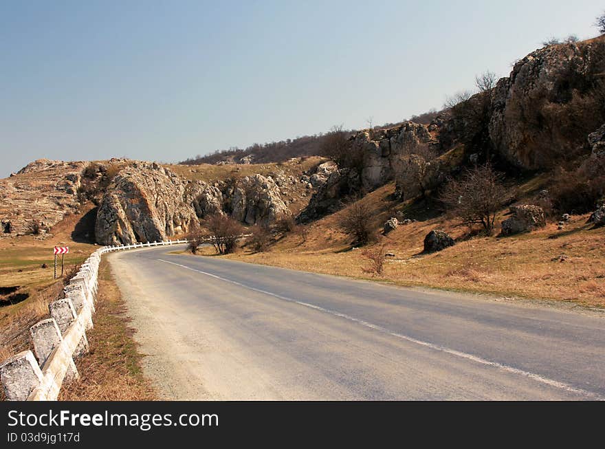 Empty country side road passing through the stony hills. Empty country side road passing through the stony hills.