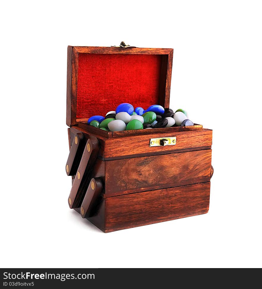 Wooden box with colored stones on a white background. Wooden box with colored stones on a white background