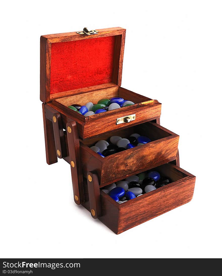 Wooden box with colored stones on a white background. Wooden box with colored stones on a white background