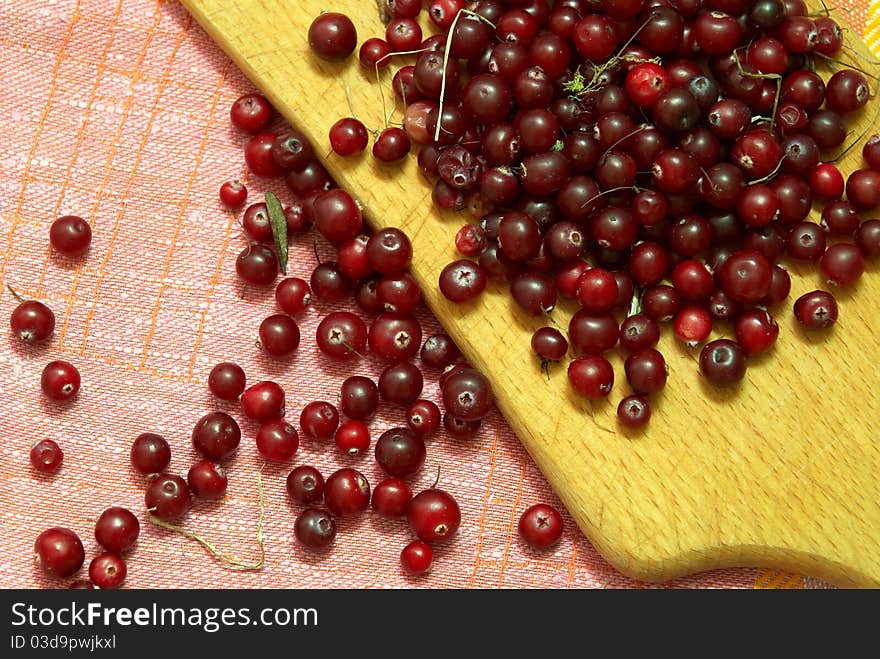 Wild cranberries on the tablecloth and hardboard