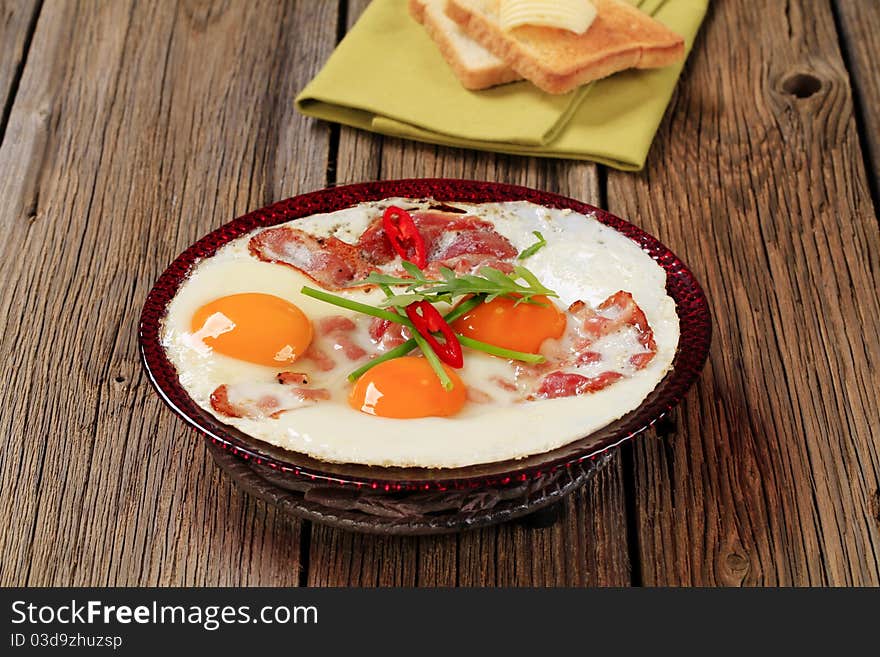 Fried eggs with slices of bacon - sunny side up. Fried eggs with slices of bacon - sunny side up