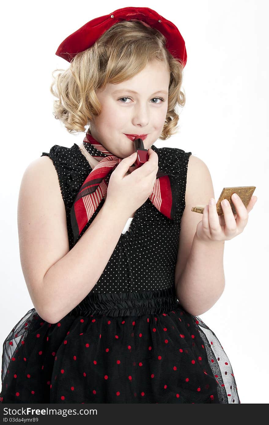 Cute little girl wearing dress putting on red lipstick. Cute little girl wearing dress putting on red lipstick