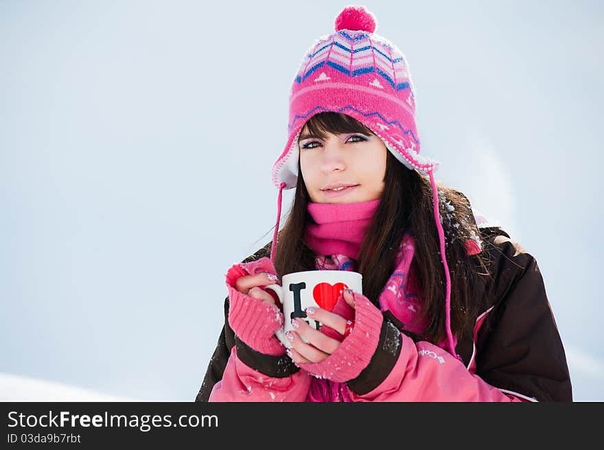 Attractive winter woman with the cup of tea on snow background. Attractive winter woman with the cup of tea on snow background