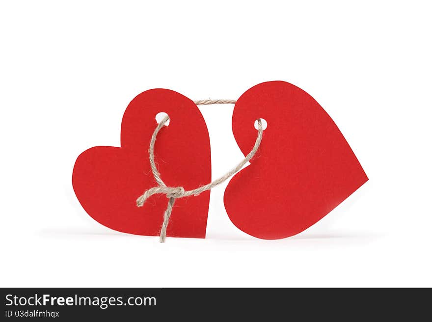 Two red paper hearts constrained with loop of rope on white background. Two red paper hearts constrained with loop of rope on white background