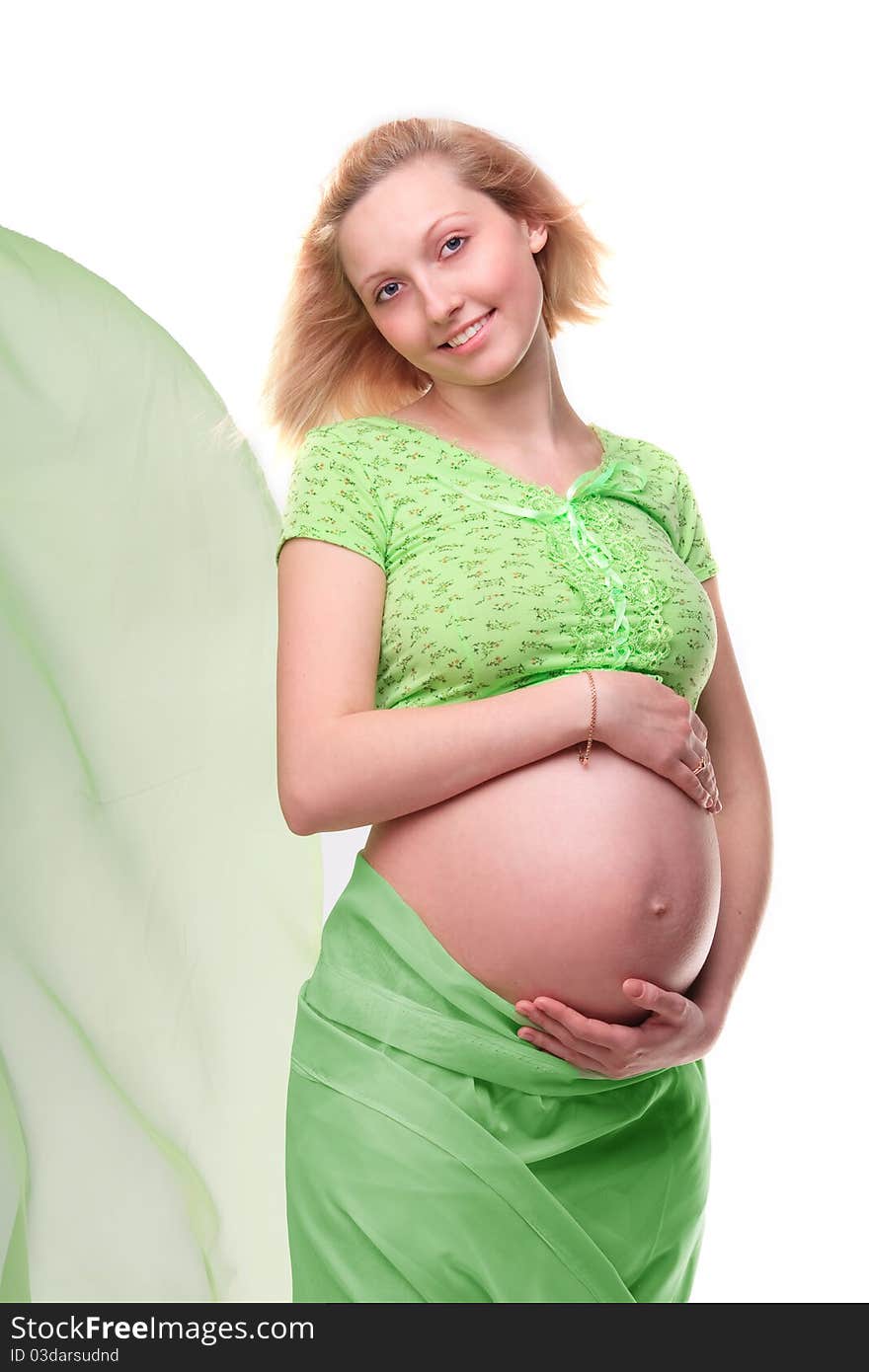 Beautiful young pregnant blonde woman with green transparent cloth in studio. Beautiful young pregnant blonde woman with green transparent cloth in studio