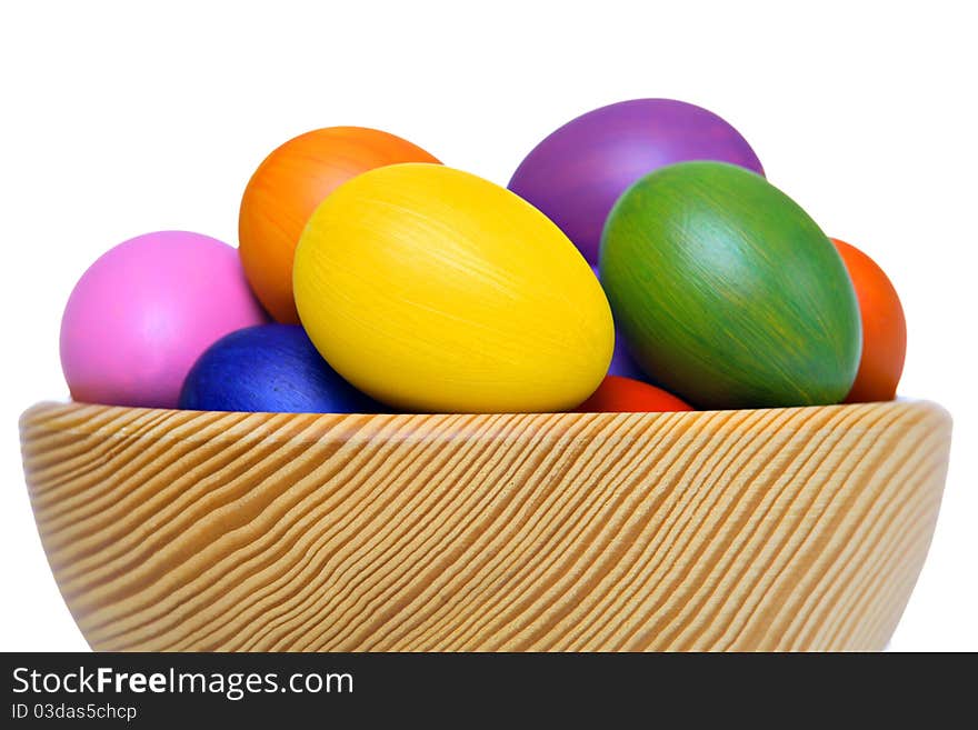 Colorful Easter eggs in wooden bowl