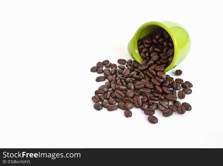 Coffee beans in green cup on white background