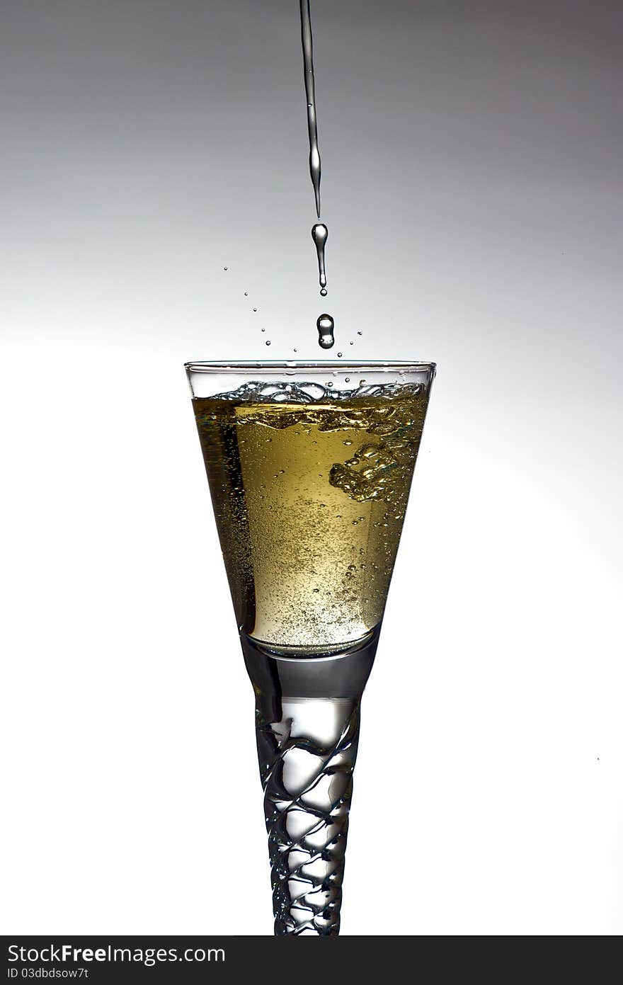 Champagne pouring into glass on gratuated background