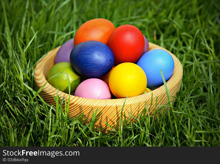 Colorful Easter eggs in wooden bowl