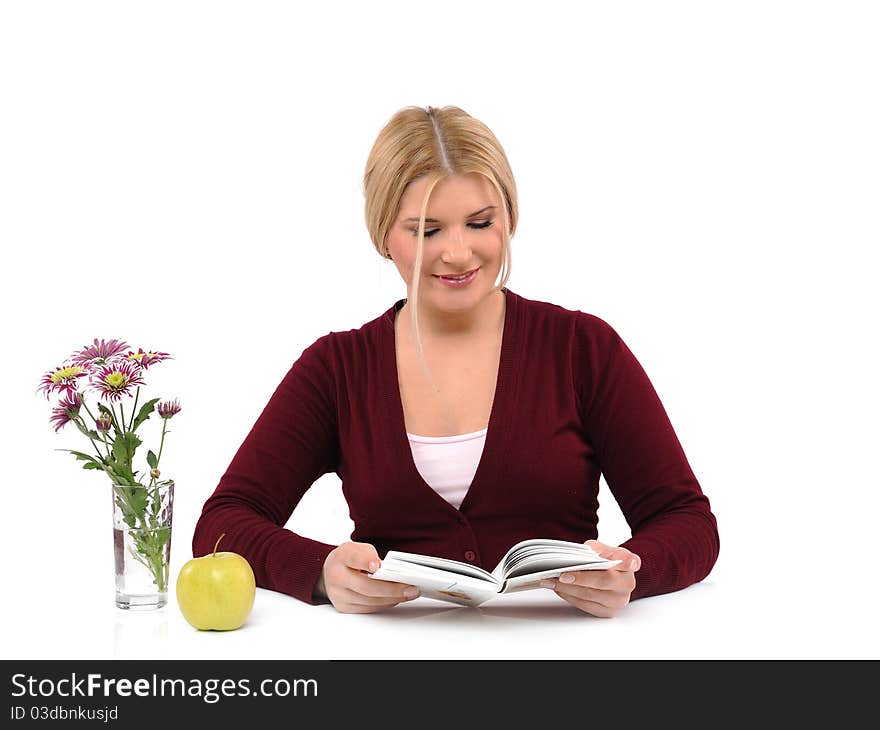 Pretty female with green apple reading book