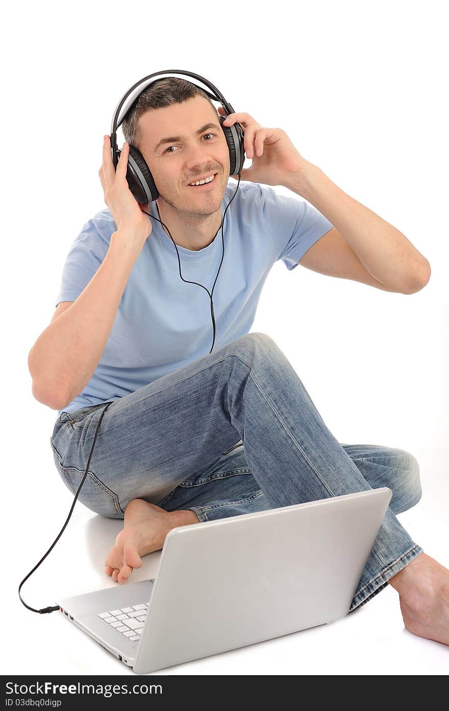 Young handsome man listening to music in headphones from computer. isolated. Young handsome man listening to music in headphones from computer. isolated