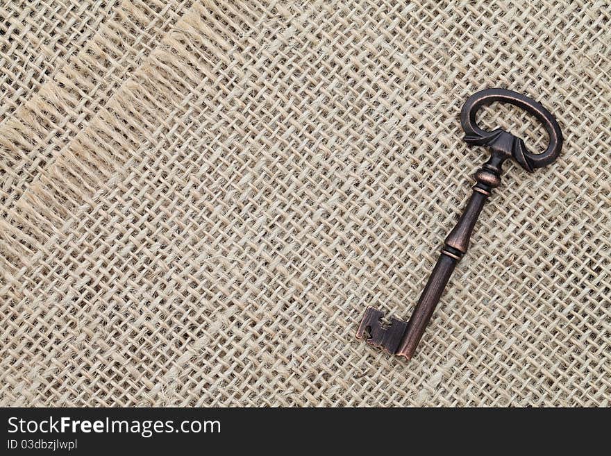 Old key on burlap background