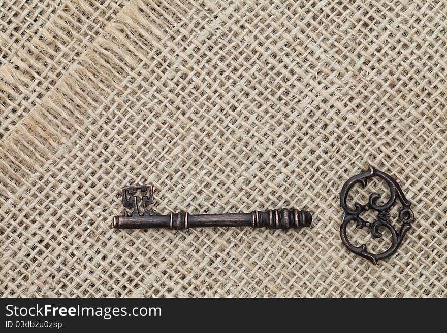 Broken old key on burlap background