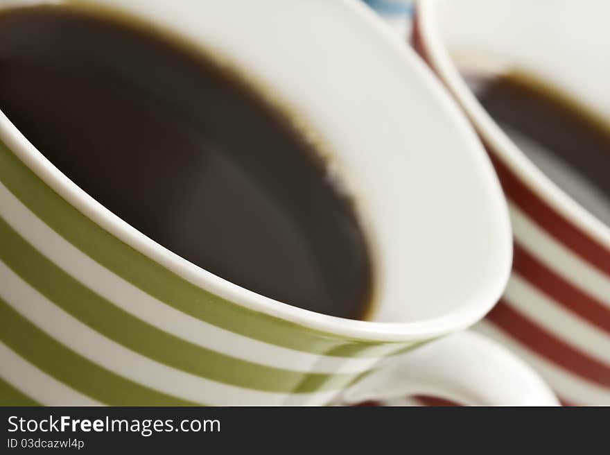 Close ups of colorful mugs of black coffee. Close ups of colorful mugs of black coffee