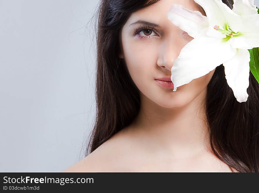 Beautiful young woman with fresh clean skin and white flower. Beautiful young woman with fresh clean skin and white flower