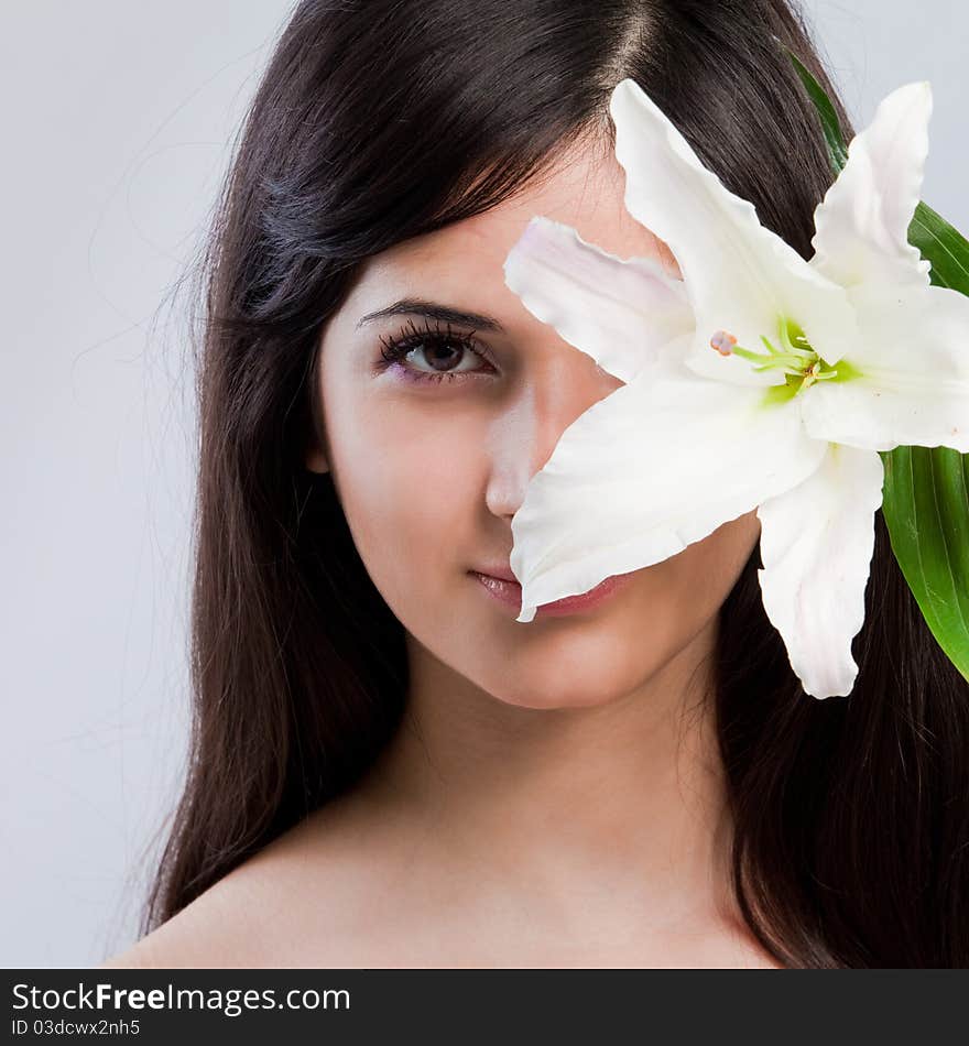 Beautiful young woman with fresh clean skin and white flower. Beautiful young woman with fresh clean skin and white flower