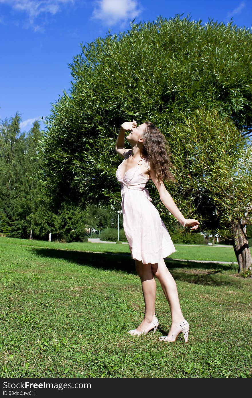 Beautiful young happy woman under blue sky.