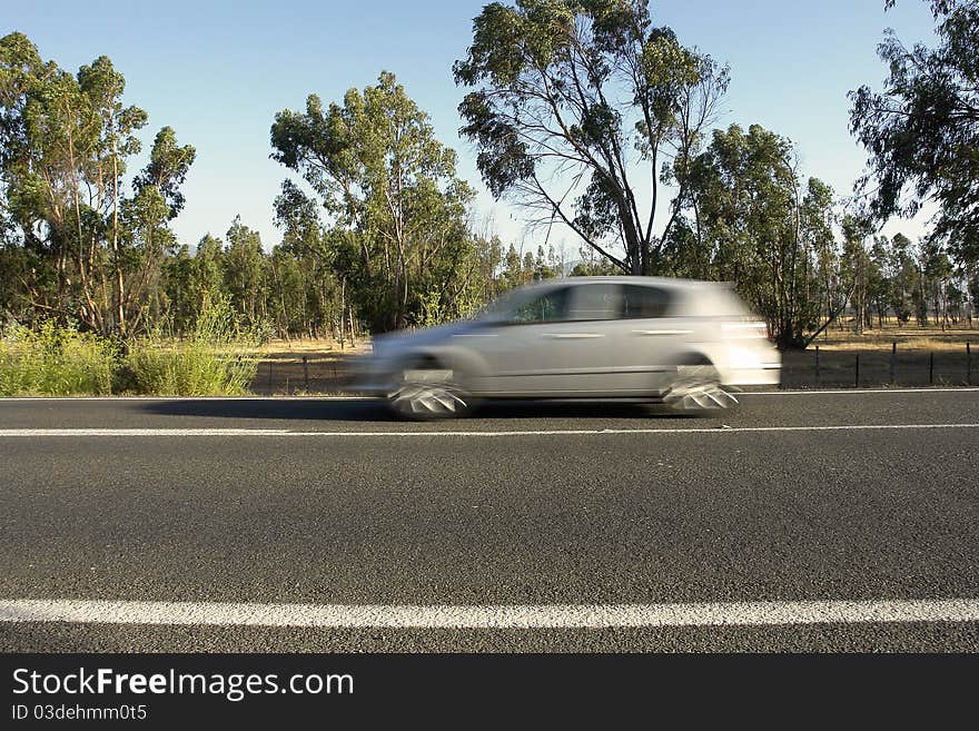 Rural road with moving automobile, excessive speed