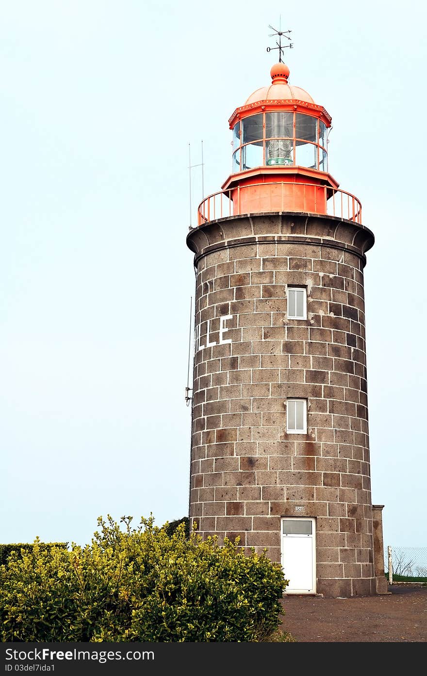 Stone build lighthouse with orange top in Granville France.