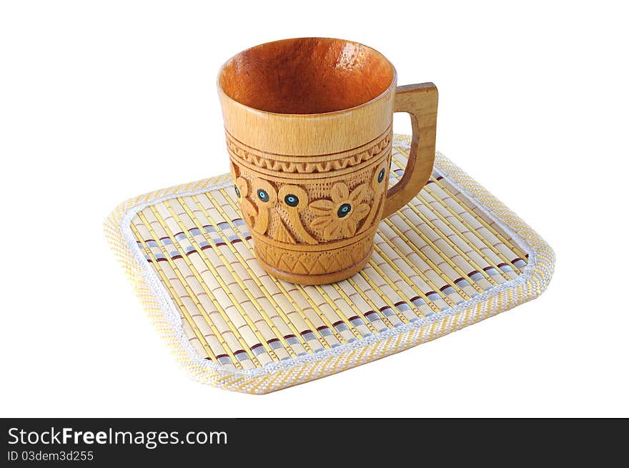 Carved Wooden Cup With A Pattern On A Bamboo Mat