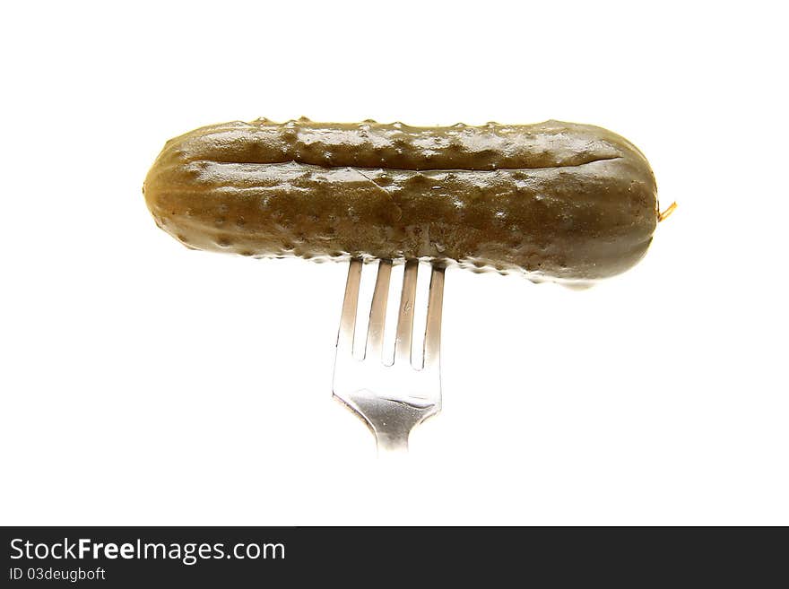 Tasty marinaded cucumber on plug on white background. Isolated.