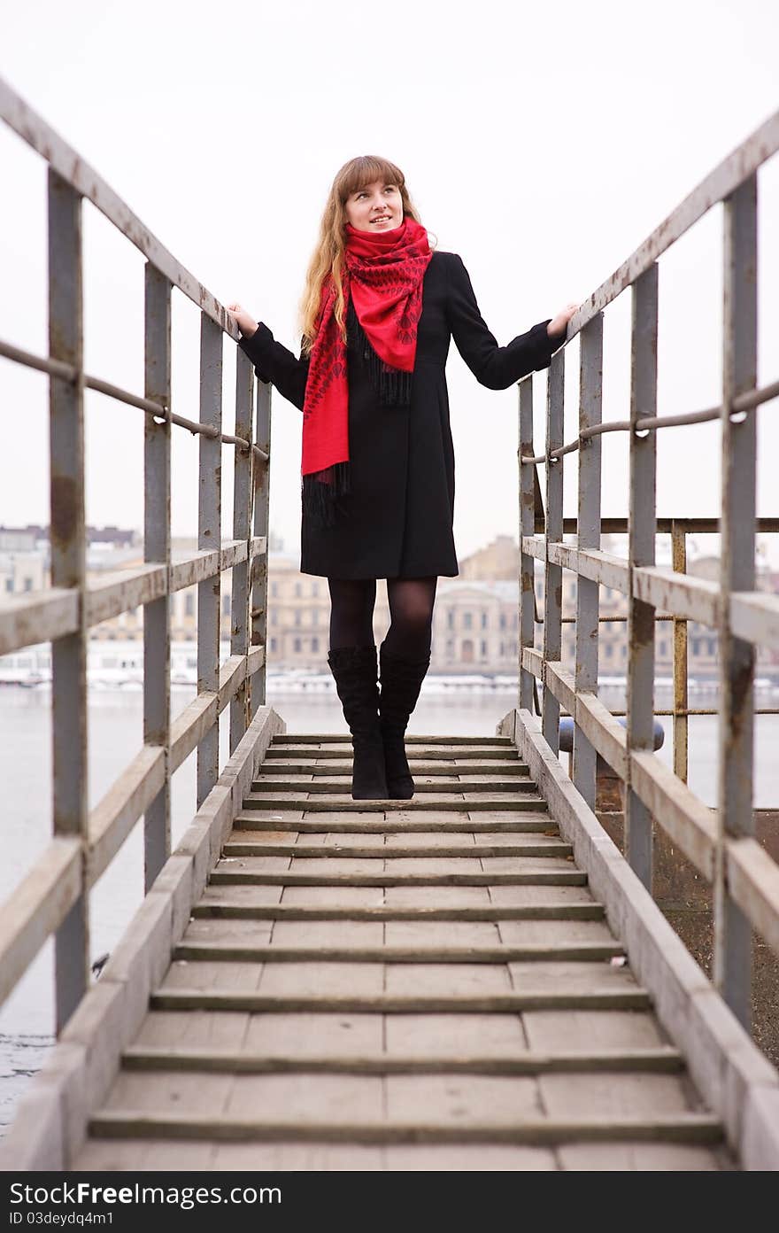 Young girl in the red scarf standing on stairs