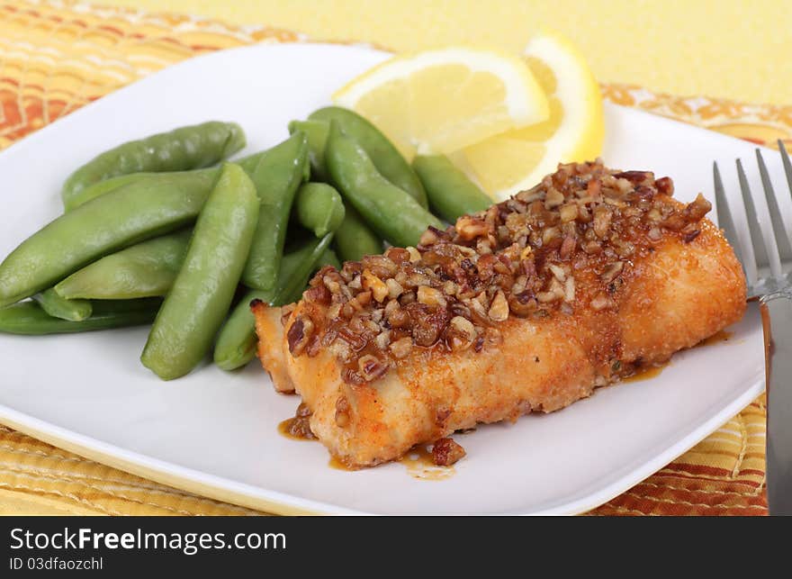 Fried cod fish fillet with snap peas and lemon slice. Fried cod fish fillet with snap peas and lemon slice