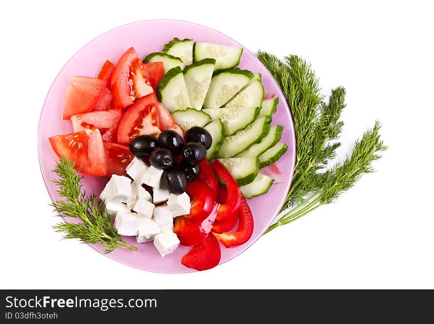 Plate of fresh cut vegetables and dill across white