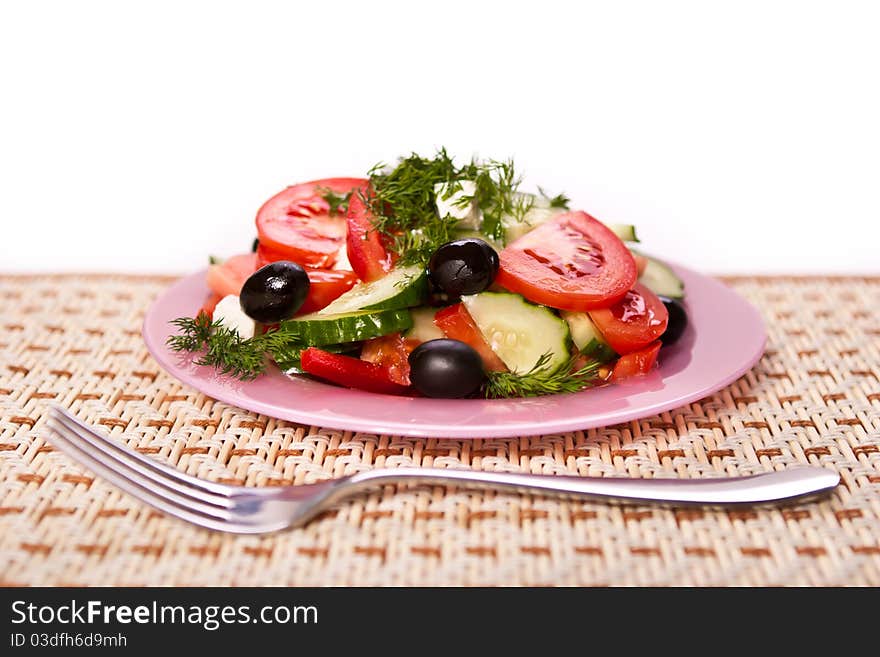 Plate of fresh salad and a fork on the napkin