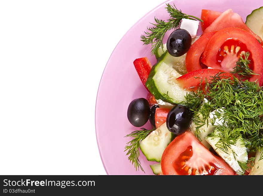 Part of plate of fresh salad across white