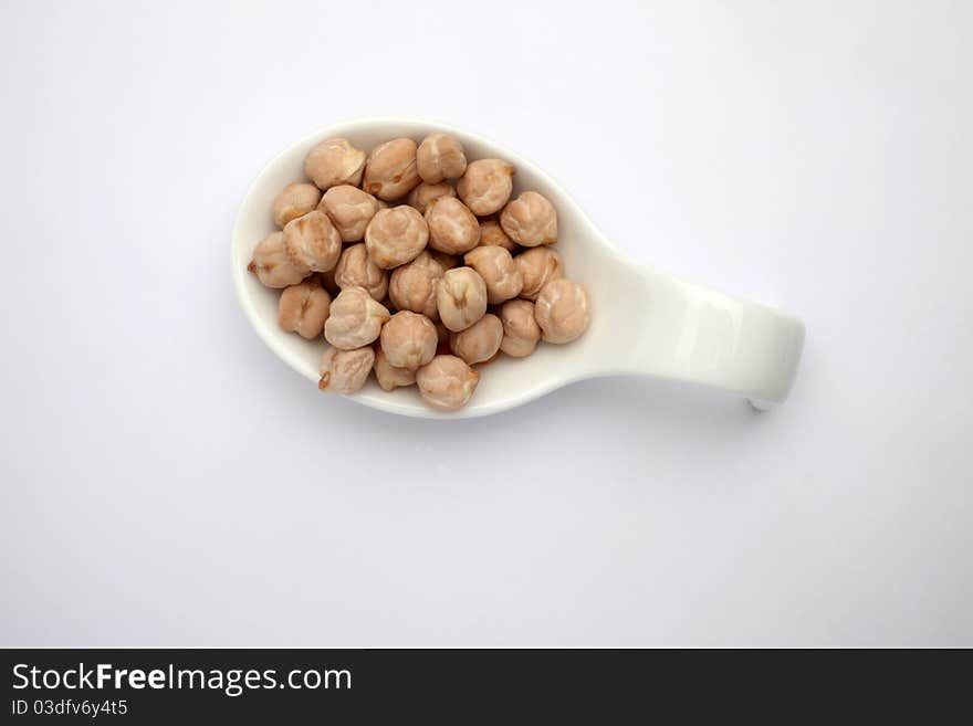 Dry raw organic chickpeas in ceramic spoon