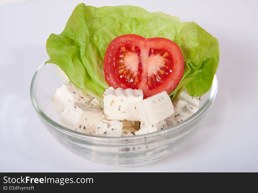 Fresh salad with tomato, feta cheese and a leaf of salad