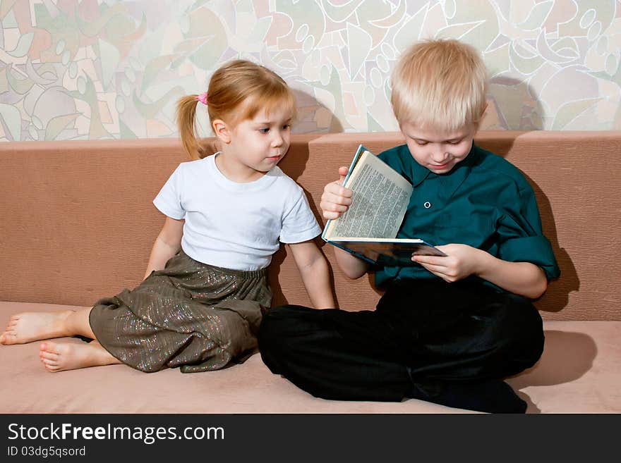 Brother and sister read a book together. Brother and sister read a book together