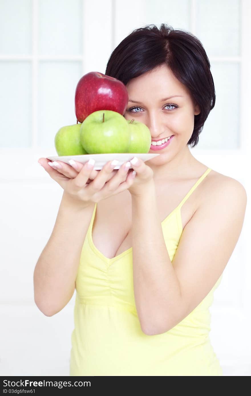 Girl holding apples on a light background