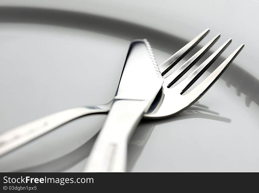 Table knife and fork over plate. Table knife and fork over plate