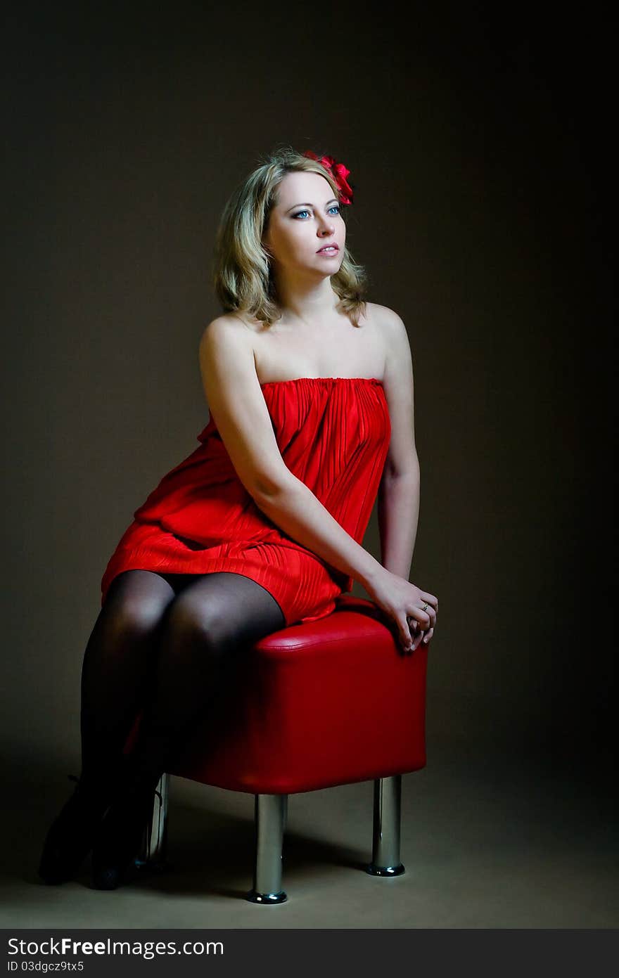 Young woman sitting on red banquette. Young woman sitting on red banquette