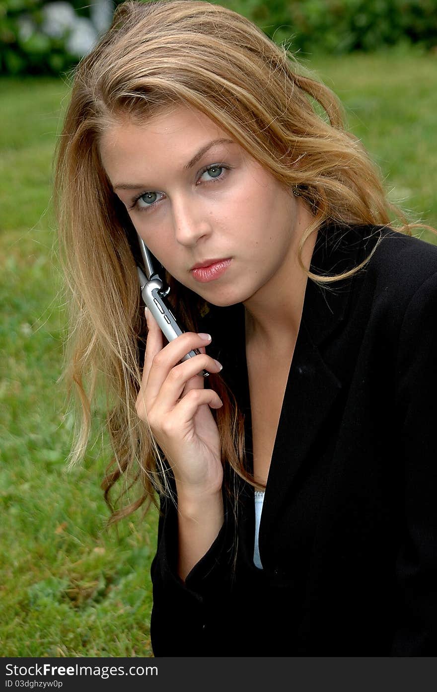 Businesswoman talking to a client on her cellphone outdoors.