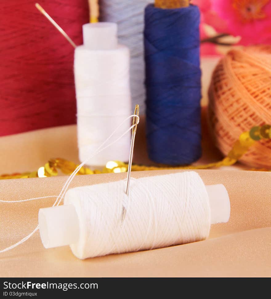 Sewing still life. Thread with a needle in the foreground