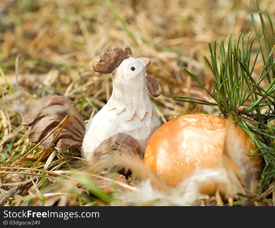 Easter Egg in  grass with chicken toy and feather