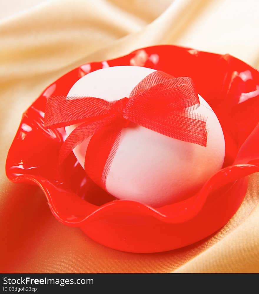 Easter still-life. Egg decorated with red ribbon