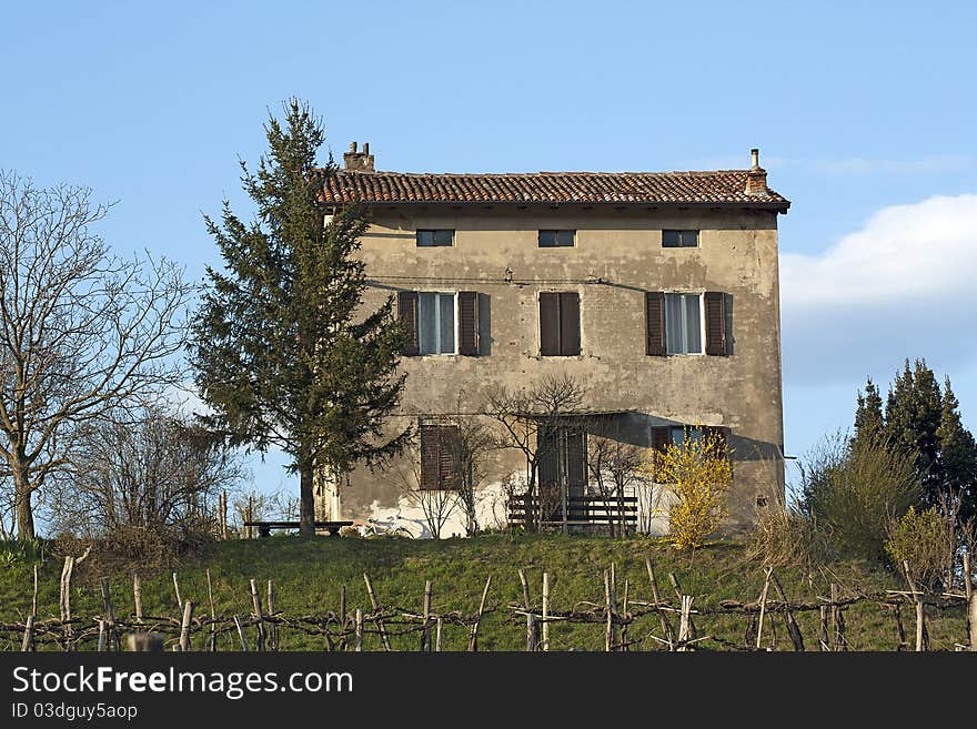 An old house on the top of a slope. The house is above the vineyard.