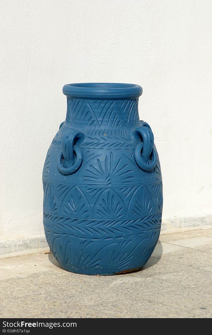 Big blue amphora on terrace against white wall. Big blue amphora on terrace against white wall